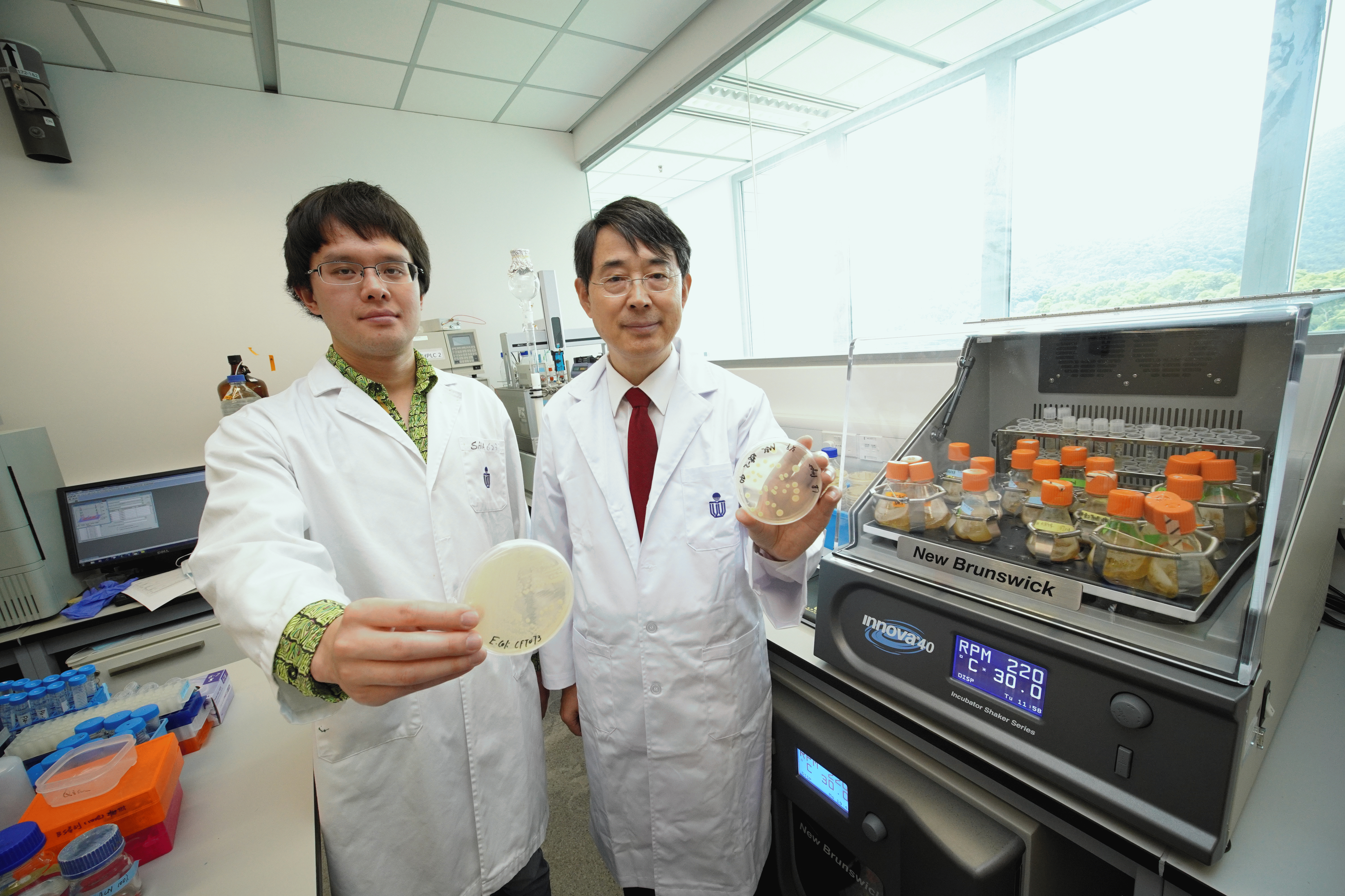 Prof. Qian Peiyuan (right) and a researcher of his team, LI Zhongrui, culture bacteria with the machine on the right.