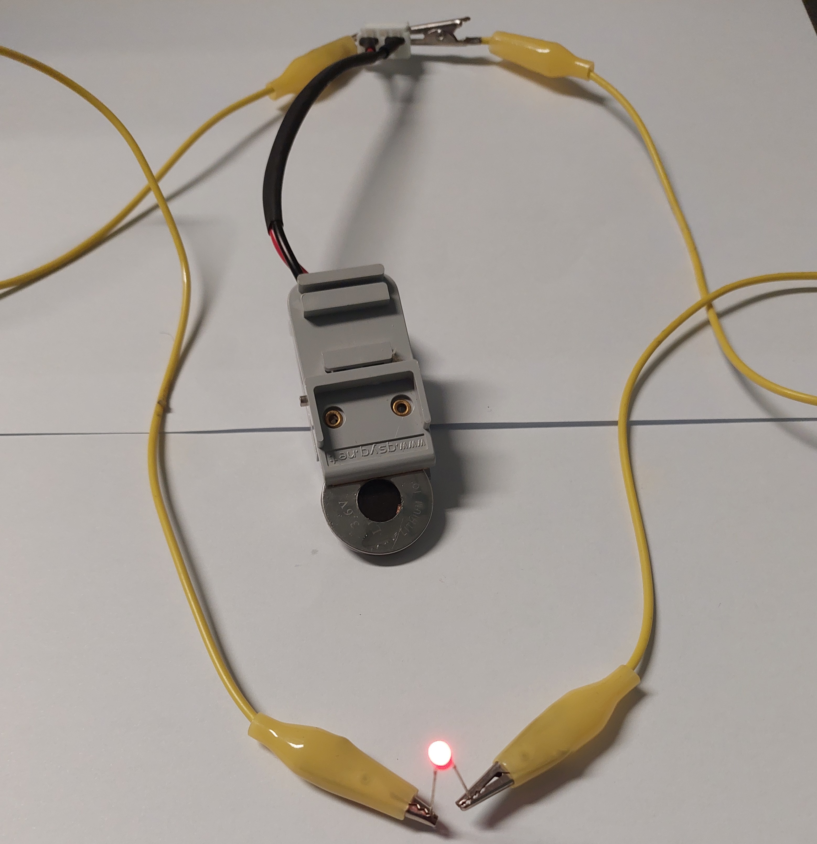 Photograph showing a photocharged Cs3Bi2I9 perovskite photo-battery powering a 1.8 V red LED.